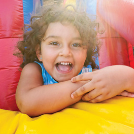 preschool-girl-smiling-portrait-in-bouncy-house-2022-10-31-09-25-48-utc